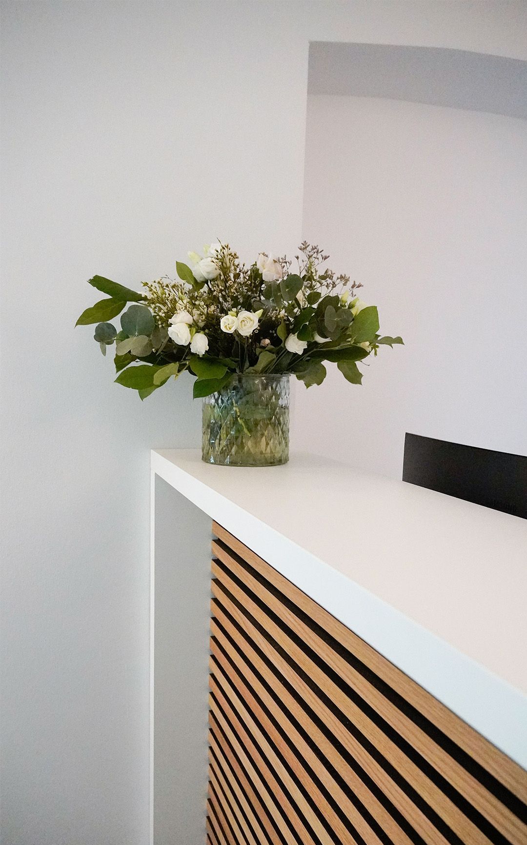 Blumen auf dem Tresen im Anmeldebereich in der Physiotherapiepraxis