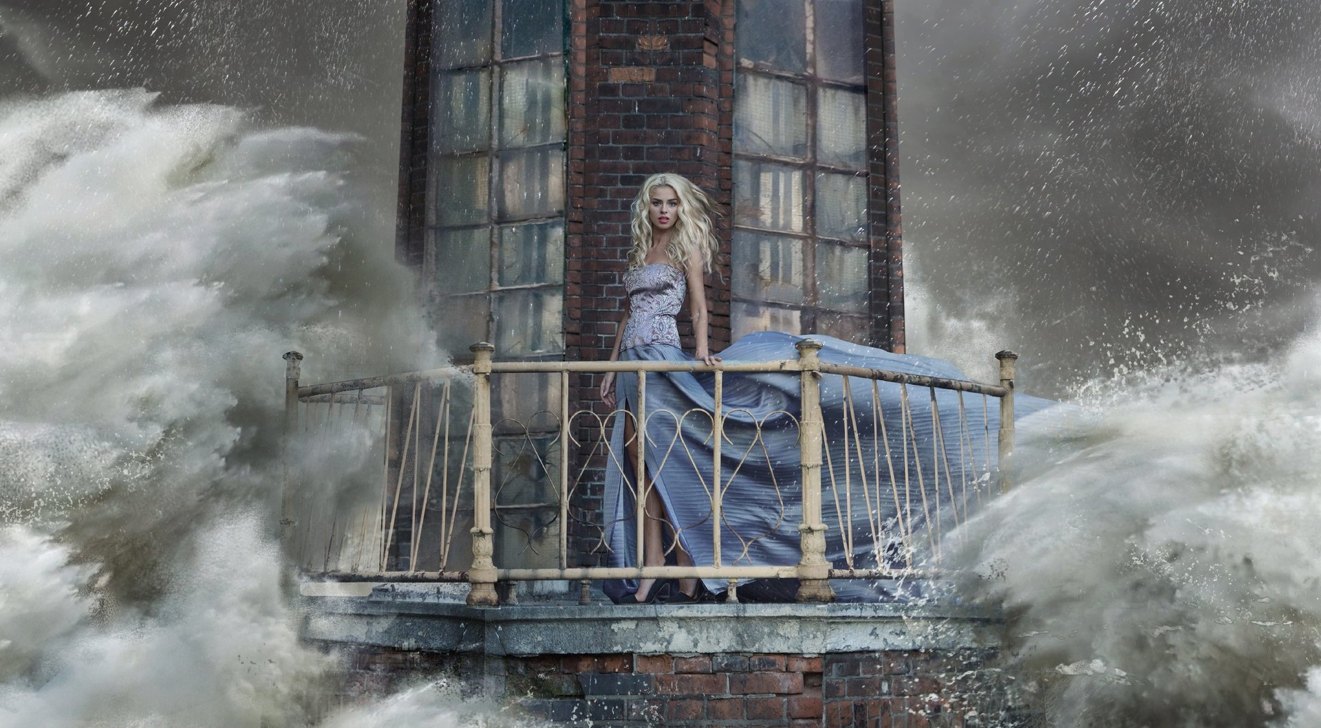 Frau in elegantem Kleid auf einen verlassenen Leuchtturm, auf den das Wasser wild und von allen Seiten einstürmt.