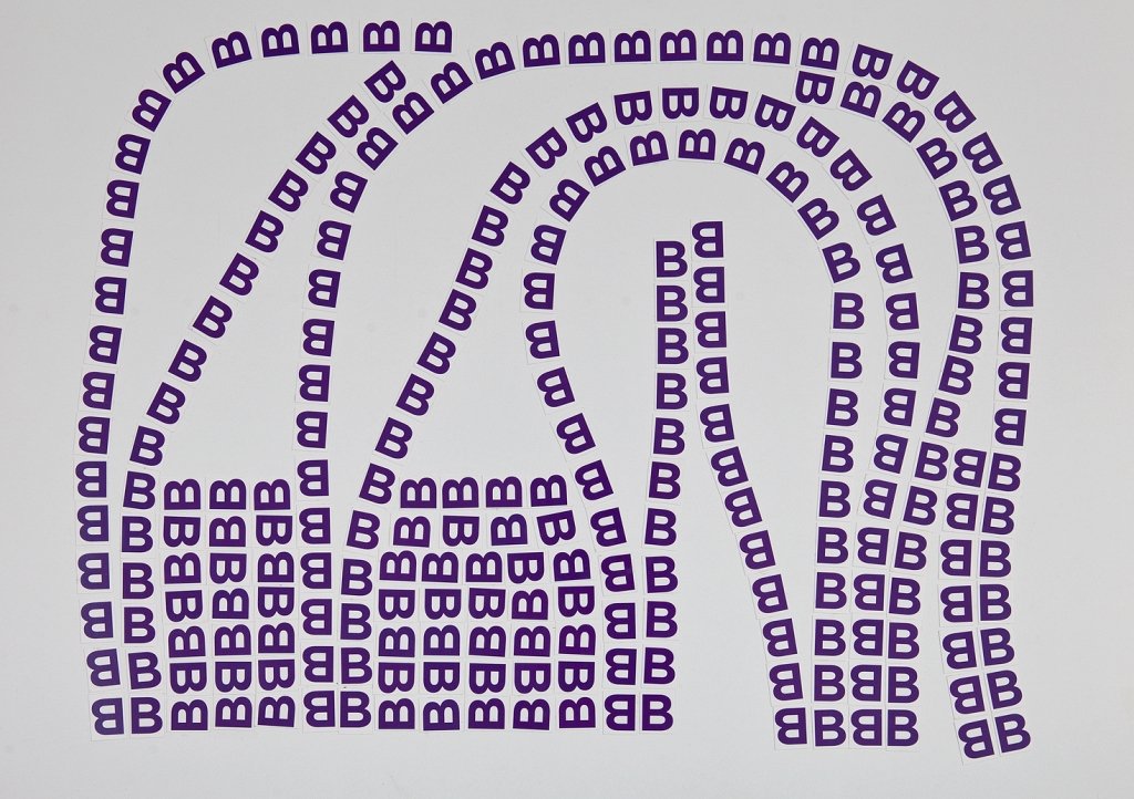„(((B)))“ – Buchstabencollage mit dem lilafarbenen B.
