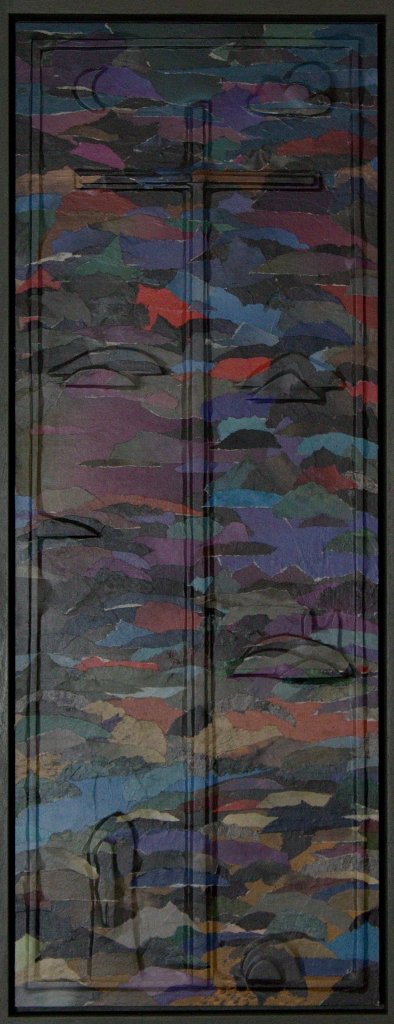 Reliefkreuz mit dunklem Grund, hellen Flecken und felinen Formen aus geschichtetem Papier.