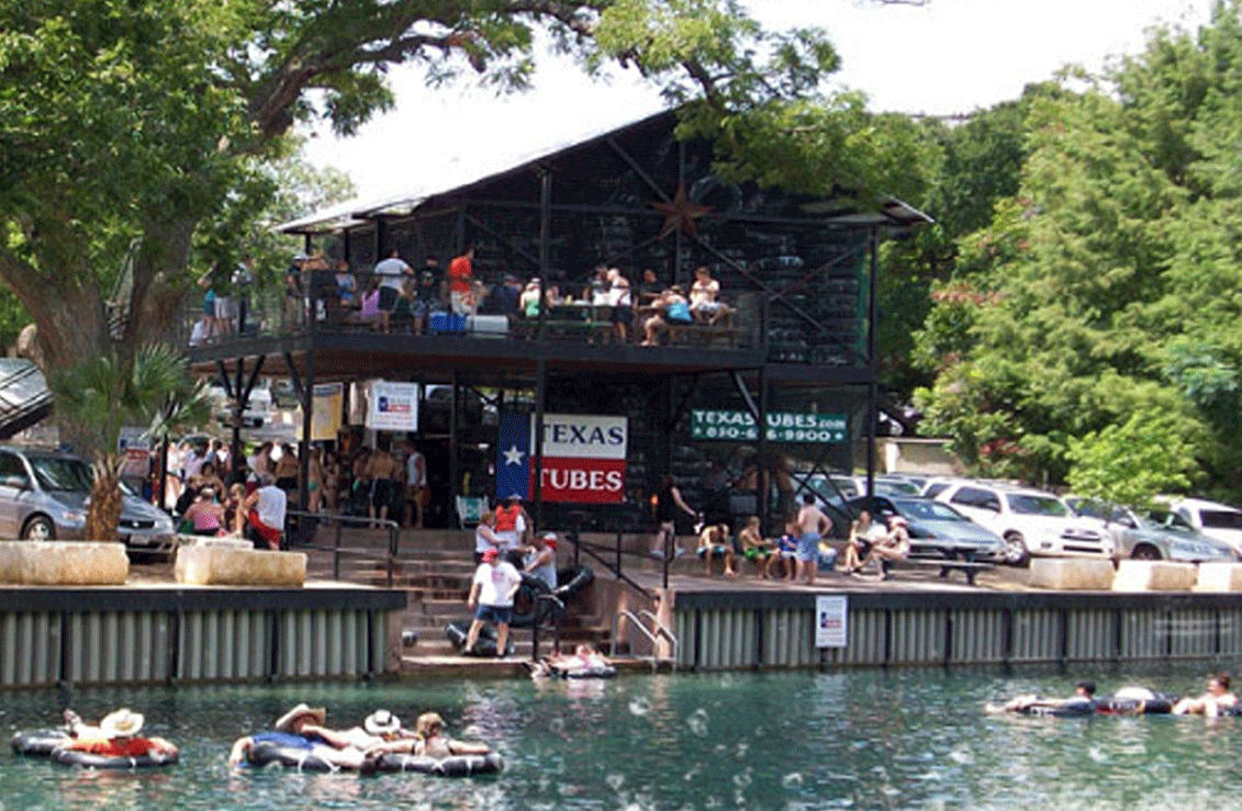 A view of Texas Tubes perched right on the shoreline of the Comal River in New Braunfels, TX., with a Private River Entry allowing super easy access into the Comal River for amazing river tubing float trips - TexasTubes.com A view of Texas Tubes perched right on the shoreline of the Comal River in New Braunfels, TX., with a Private River Entry allowing super easy access into the Comal River for amazing river tubing float trips - TexasTubes.com
