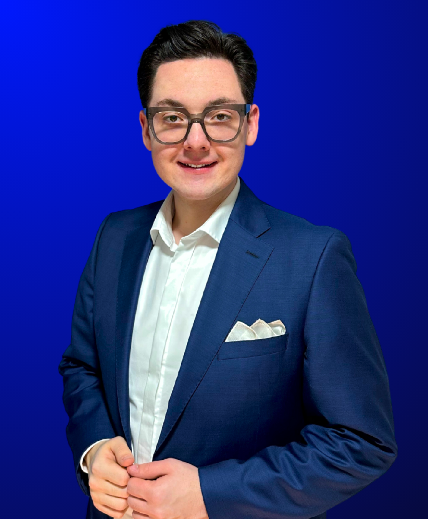 Porträt von Ricardo Dietl, Präsident der Bundesverbraucherhilfe e.V., mit weißem Hemd, dunklem Sakko und markanter Brille vor einem blauen Hintergrund.