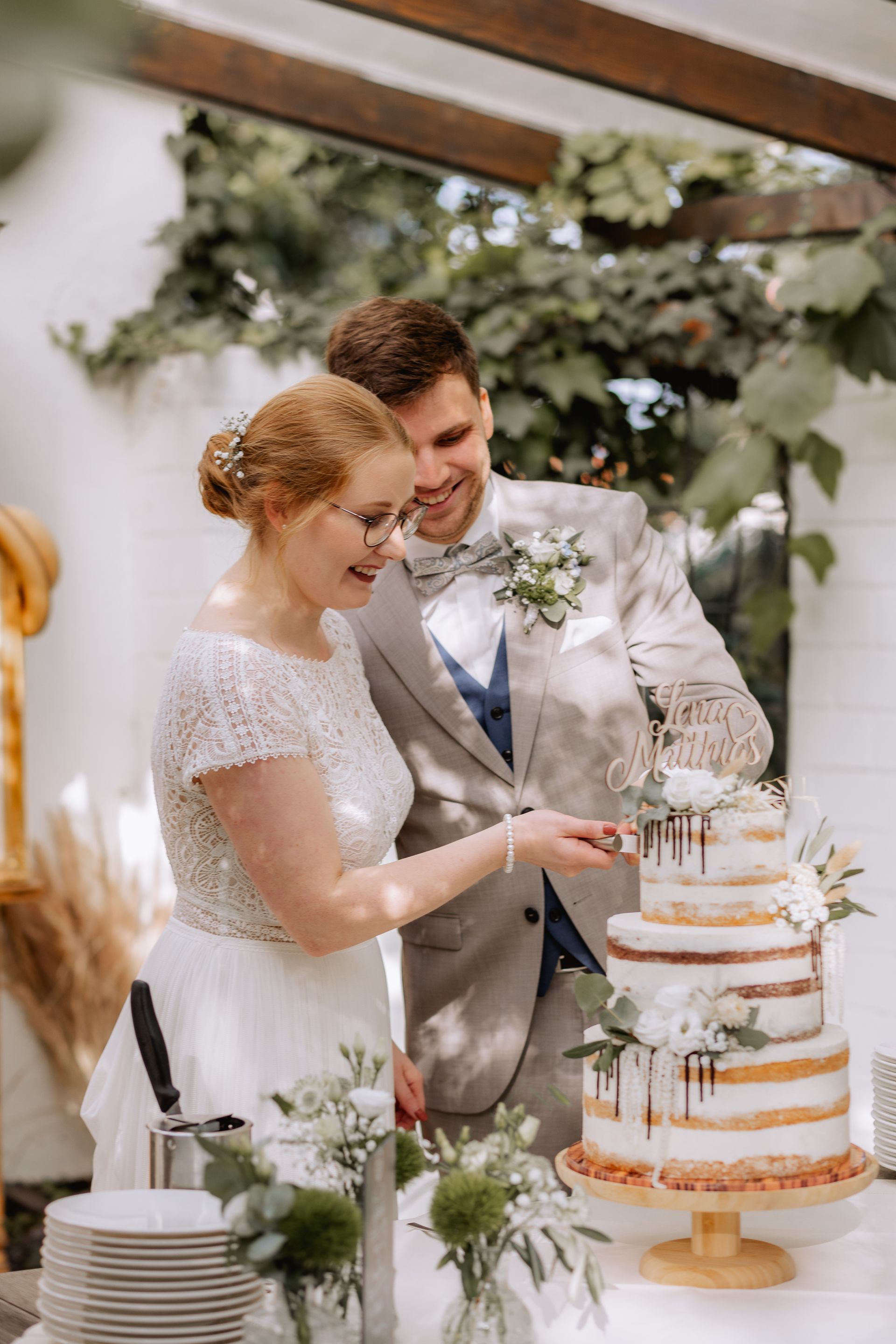 Brautpaar schneidet gemeinsam die Hochzeitstorte an